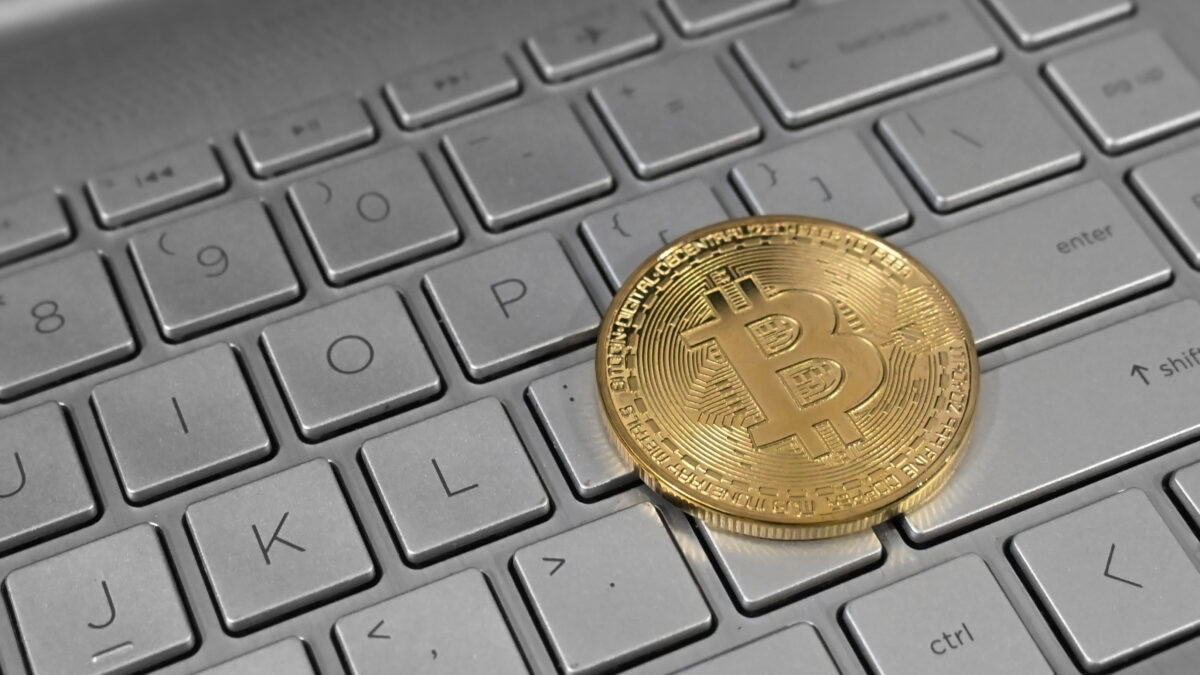 Una moneda de bitcoin sobre el teclado de una computadora portátil