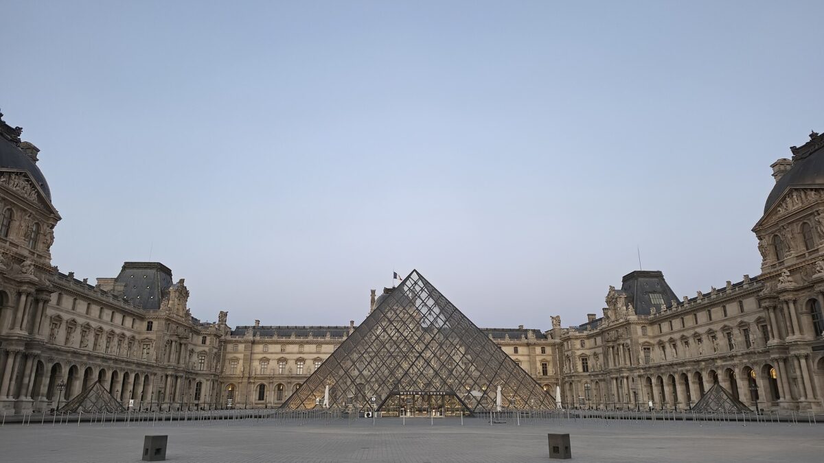 Pirámide del Louvre y patio Napoleón en París con visitantes